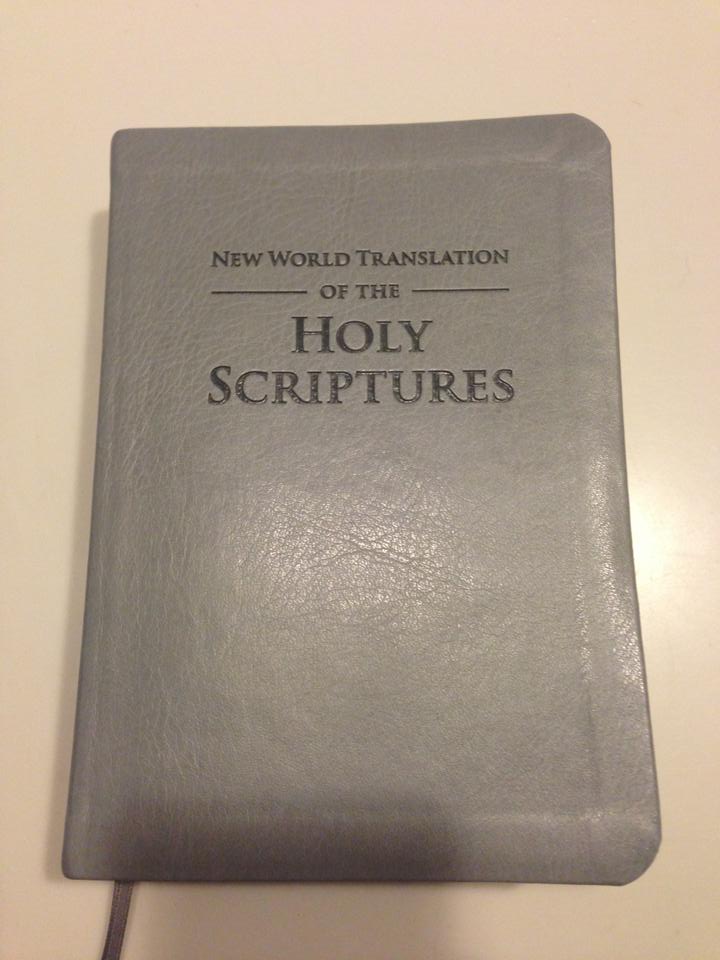 A Revisão da Tradução do Novo Mundo das Escrituras Sagradas (em inglês) possui uma capa de couro acinzentada.